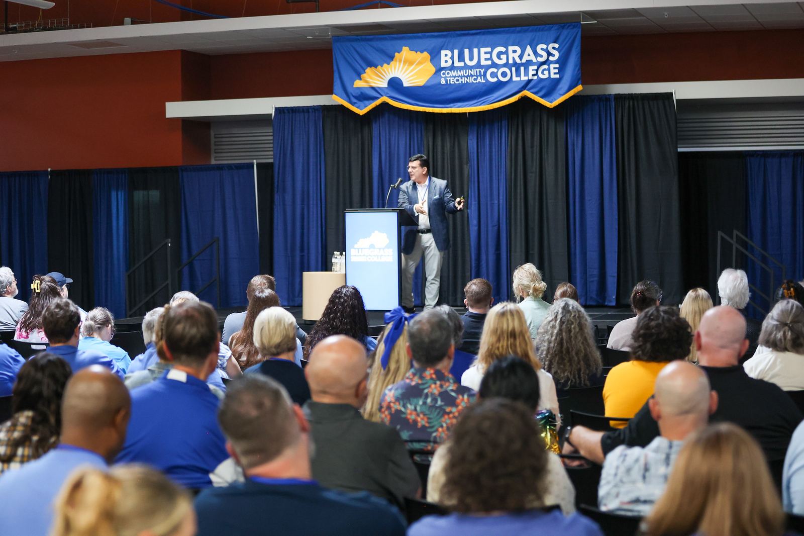 David Dean Mauro speaking on stage to a live audience