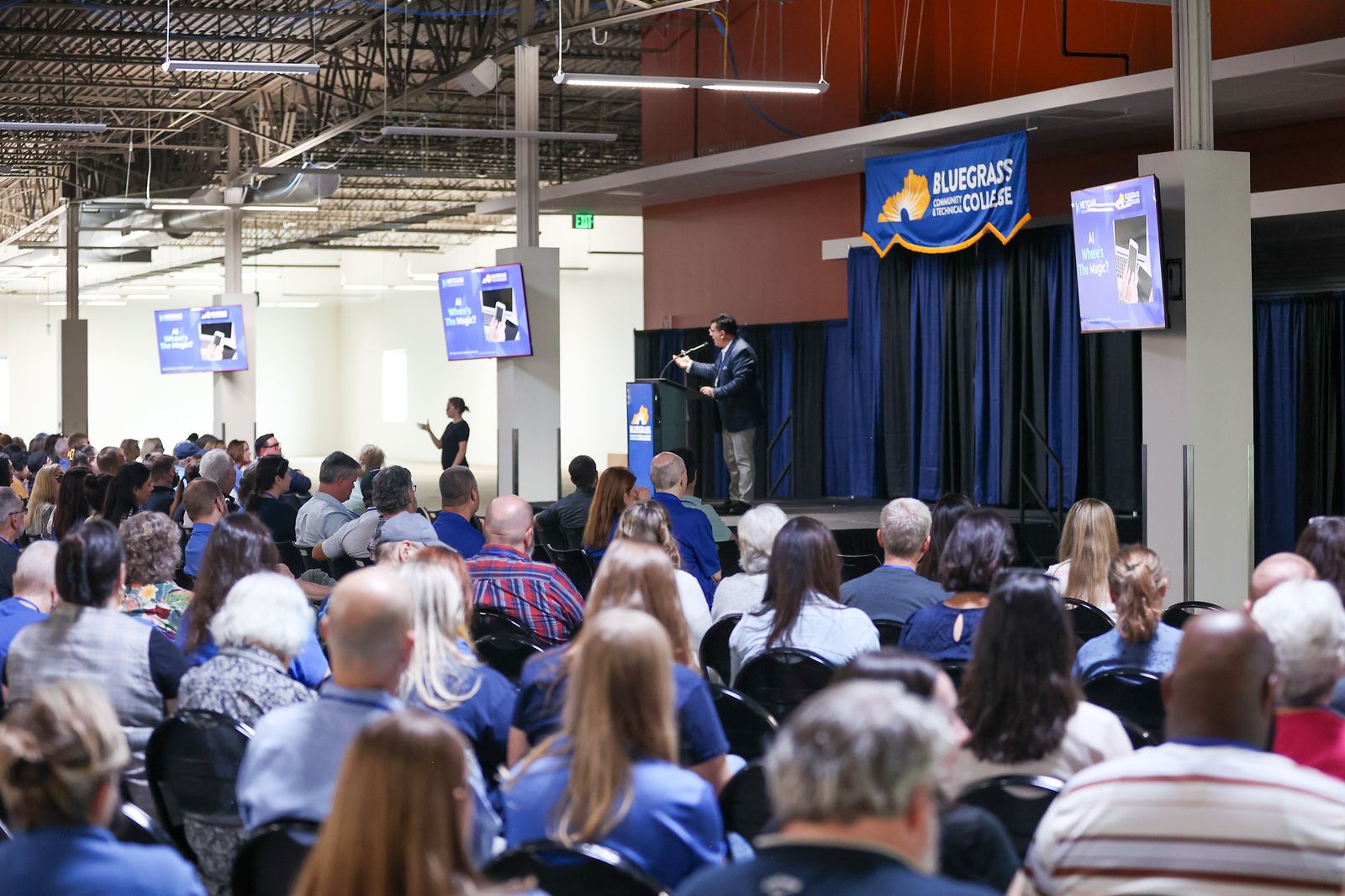 A full room of attendees at a live AI and cybersecurity keynote