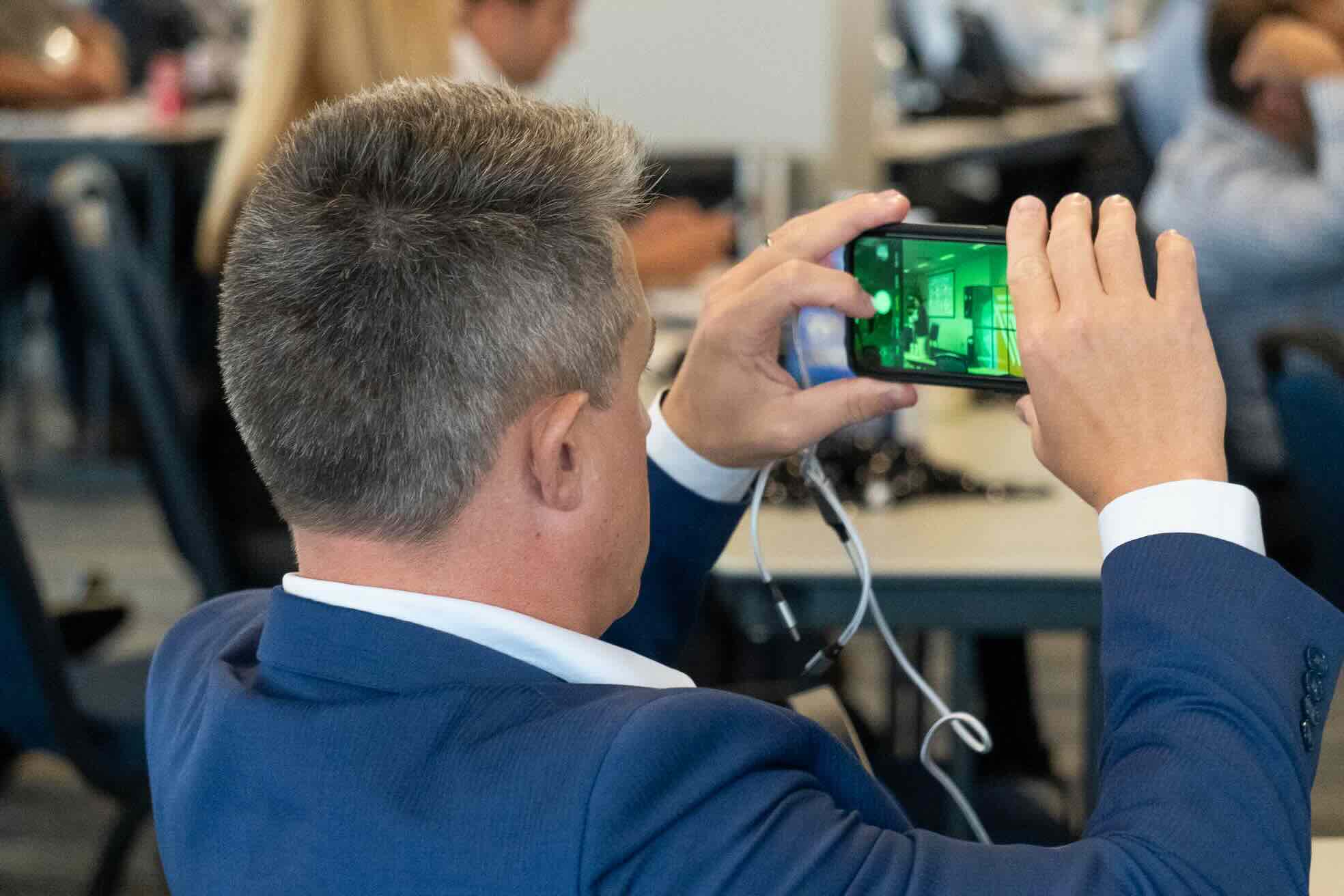 Attendee photographing a slide during a live cyber training